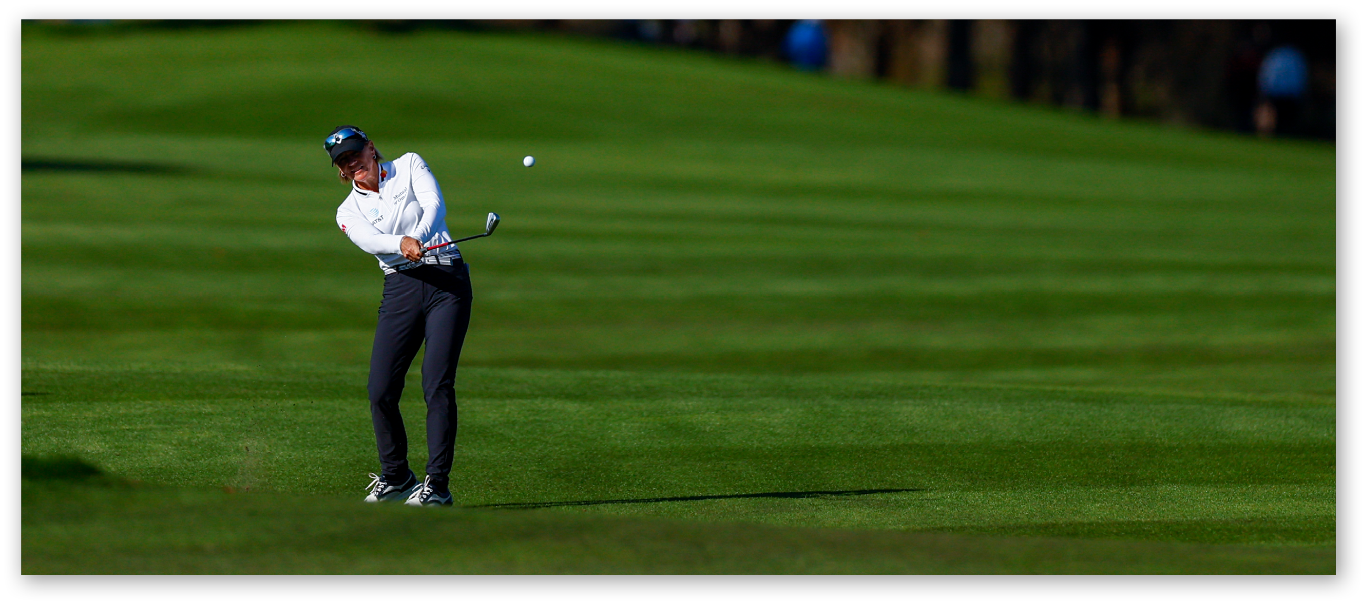 A man is swinging a golf club on a green course.

Description generated by AI
